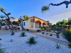 una casa con árboles delante de ella en New holiday house "Casa miAlina" with private pool, 300m to beach en Cambrils