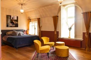 a bedroom with a bed and two yellow chairs at Herberg d'n brouwer in Zeeland