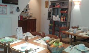 a dining room with a table with a basket of fruit at AUBERGE du BORD des EAUX - Demi-pension assurée sur réservation in Saint-Amand-les-Eaux