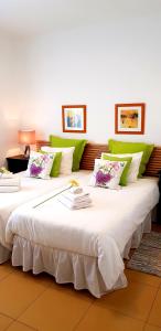 two large white beds with green and white pillows at Apartamento Dorada Alto in Playa Blanca