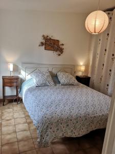 a bedroom with a bed with a blue and white comforter at La Petite Seigneurette in Villeneuve-lès-Avignon