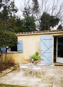 a patio with a table and chairs and a blue door at La Petite Seigneurette in Villeneuve-lès-Avignon