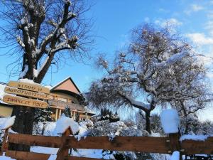 a fence in front of a house covered in snow at Agroturystyka Iwańcze Pole in Iwonicz-Zdrój