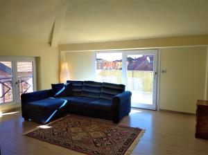 uma sala de estar com um sofá azul e um tapete em Appartamento Adriana em Baveno