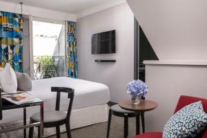 Una habitación de hotel con una cama, una mesa y sillas. en Les Matins de Paris & Spa, en París