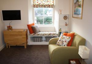 sala de estar con sofá, silla y ventana en Rockpool Apartment en North Berwick