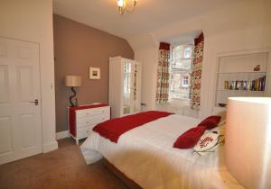 um quarto com uma cama grande e almofadas vermelhas em Rockpool Apartment em North Berwick