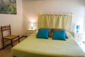 - une chambre avec un lit doté d'oreillers bleus et d'une chaise dans l'établissement AUBERGE du BORD des EAUX - Demi-pension assurée sur réservation, à Saint-Amand-les-Eaux