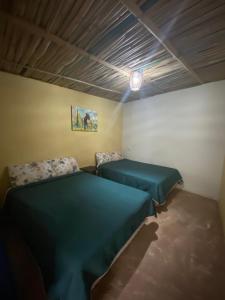 1 dormitorio con 2 camas y techo en Miroji, en Zacatlán