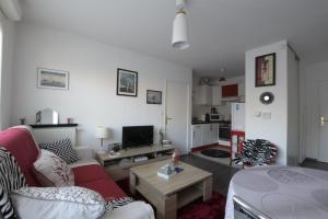 uma sala de estar com um sofá e uma mesa em Jasmin em Rouen