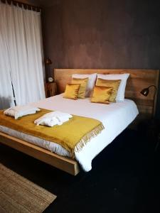 ルッデルフォールデにあるCasa Leone near Bruges with jacuzzi & parkingの大型ベッド(白いシーツ、黄色い枕付)