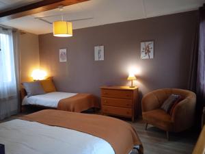 een hotelkamer met 2 bedden en een stoel bij Aux 10 Ponts - Gîte aux abords du fleuve La Somme - La mer à 30 min - La nuit pour 6 voyageurs in Pont-Rémy