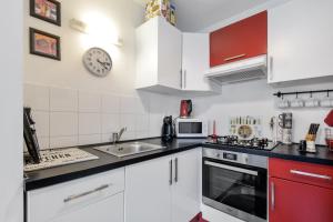 a kitchen with white cabinets and a sink at Jasmin in Rouen