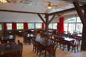 a restaurant with tables and chairs and red curtains at Pullman City Westernstadt in Eging am See