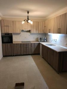 an empty kitchen with wooden cabinets and a sink at Pelso Vendégház in Balatonberény