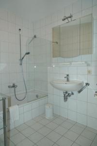 a white bathroom with a sink and a shower at Ferienwohnungen an der Therme in Bad Rodach