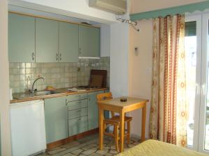 a small kitchen with a table and a sink at Green Hill Studios & Apartments in Kokkari