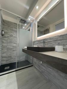 Un baño con lavabo y ducha de cristal. en Rossella’s home, en Palermo