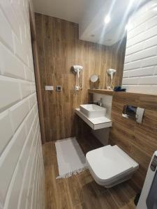 uma casa de banho com um WC e um lavatório em Zakątek Bór, nowoczesne domki nad rzeką em Bór