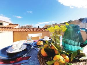 una mesa con platos y un jarrón y fruta. en Appartamento elegante a Marina di Campo en Campo nell'Elba