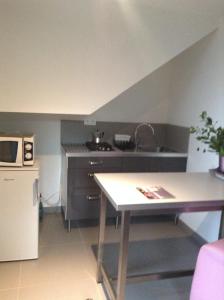 a small kitchen with a sink and a table at Meublés Les Charmettes in Chambéry