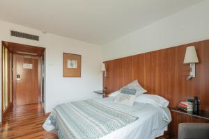 1 dormitorio con 1 cama grande y cabecero de madera en Micampus Pamplona, en Pamplona