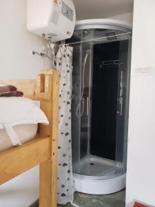 a shower with a glass door in a bedroom at Hostel La Cruz del Sur in La Paloma