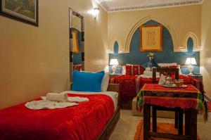 a bedroom with two beds with red and blue at Riad Merzouga in Marrakech