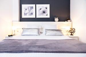 sypialnia z dużym łóżkiem z dwoma obrazami na ścianie w obiekcie Feelathome Poblenou Beach Apartments w Barcelonie