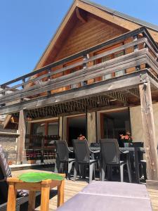 een huis met stoelen en tafels op een terras bij Le GrandCoeur in Le Bourg-dʼOisans