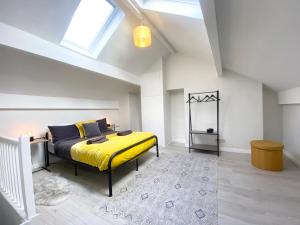 a bedroom with a yellow bed in a attic at Bronte Nook, Haworth Village, Bronte Country in Haworth
