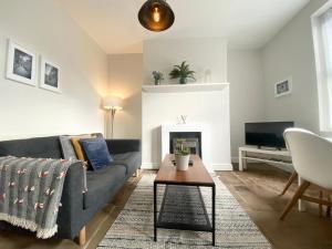 a living room with a couch and a fireplace at Bronte Nook, Haworth Village, Bronte Country in Haworth