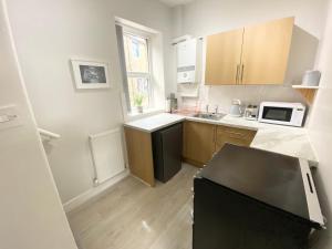 a kitchen with a sink and a microwave at Bronte Nook, Haworth Village, Bronte Country in Haworth