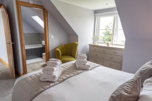 a bedroom with a bed with towels on it at The Annexe, Luxury Property with Hot Tub at Pitilie Pods in Aberfeldy