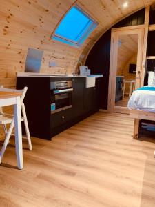 1 dormitorio con cama, escritorio y ventana en Thistle Pod at Ayrshire Rural Retreats Farm Stay Hottub Sleeps 2 en Galston