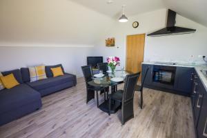 uma sala de estar com uma mesa e um sofá azul em Holllie View em Enniskillen
