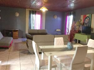 un soggiorno con un tavolo e un divano di Villa chaleureuse près de Le Tampon avec piscine partagée a Le Tampon