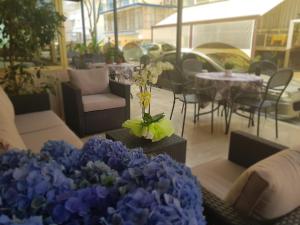 a patio with a table with blue flowers and chairs at HOTEL ROMANTICA in Rimini