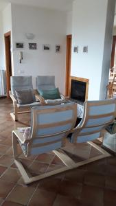 sala de estar con 2 sillas y chimenea en El Rincon del Artista, en Soiano del Lago