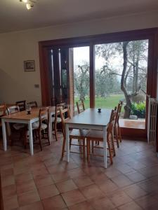 een eetkamer met tafels en stoelen en een groot raam bij El Rincon del Artista in Soiano del Lago