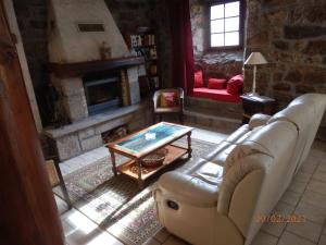 a living room with a couch and a fireplace at GITE LES MYOSOTIS in Le Chambon-sur-Lignon