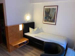 a small room with a bed and a chair at Hotel Martina in Bad Sooden-Allendorf