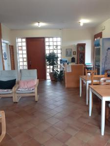- un salon avec des chaises, des tables et des fenêtres dans l'établissement El Rincon del Artista, à Soiano del Lago