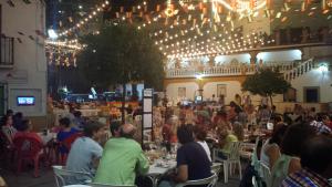 a group of people sitting at tables in a restaurant at Villa Perla Blanca in Sayalonga +64 photos