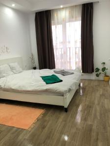 Ştefăneştii de JosDora High Life - North的卧室铺有木地板,配有一张白色的床。 更多36张照片