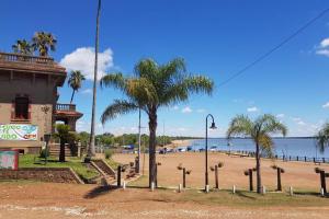 a beach with palm trees and a street light at Colòn Termas y Playa - Departamento 2 a 4 personas in Colón