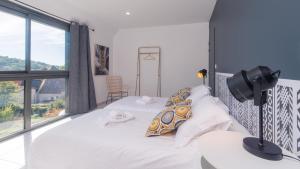 a bedroom with two beds and a large window at 100% Relax avec Jacuzzi Privatif in Sarlat-la-Canéda