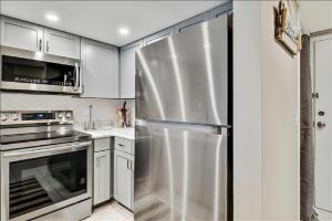 a stainless steel refrigerator in a kitchen with white cabinets at Unit 3206 - Ocean & Racquet Resort in Saint Augustine Beach