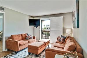 Una sala de estar con dos sofás de cuero y un televisor. en Unit 3206 - Ocean & Racquet Resort, en St. Augustine Beach