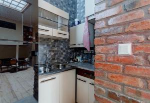cocina con pared de ladrillo y fregadero en lovely Dulcet Loft In Center Of Rustaveli, en Tiflis